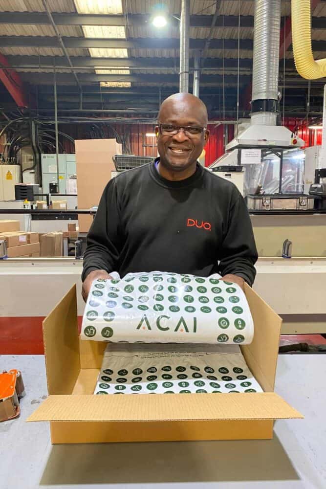 Duo Packaging employee holding ACAI Outdoorwear Branded Mailing Bags manufactured at Manchester HQ.